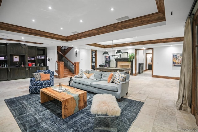 living room featuring a tray ceiling, stairs, baseboards, ornamental molding, and recessed lighting