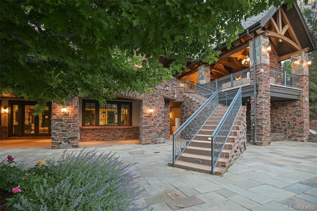property entrance with a patio area and stone siding