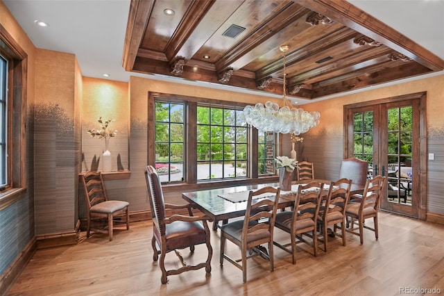 dining room with light wood-style floors, healthy amount of natural light, a chandelier, baseboards, and crown molding