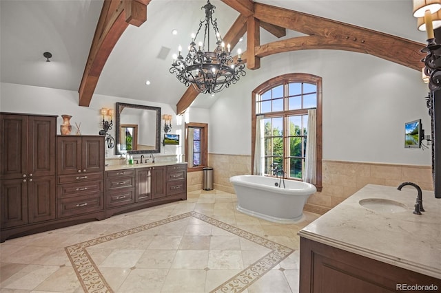 bathroom with tile walls, wainscoting, vanity, a soaking tub, and beam ceiling