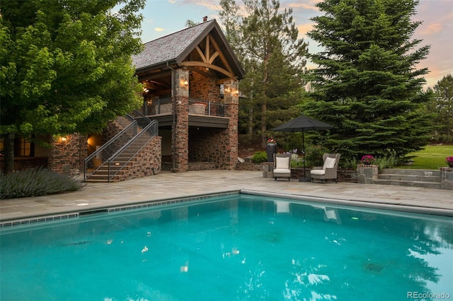 swimming pool with stairway and a patio