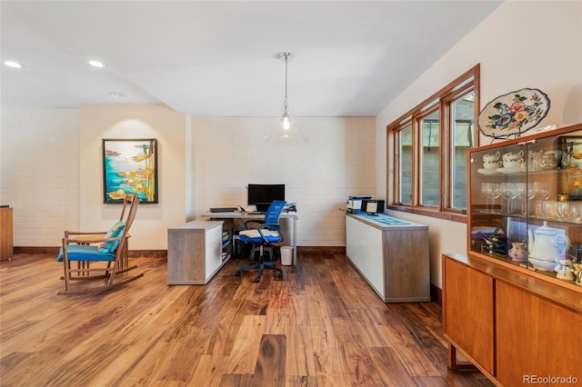 office area featuring hardwood / wood-style flooring and brick wall