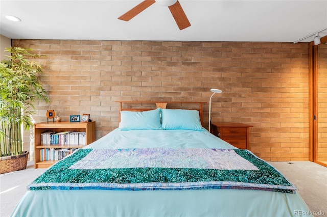 unfurnished bedroom featuring brick wall, carpet, and ceiling fan