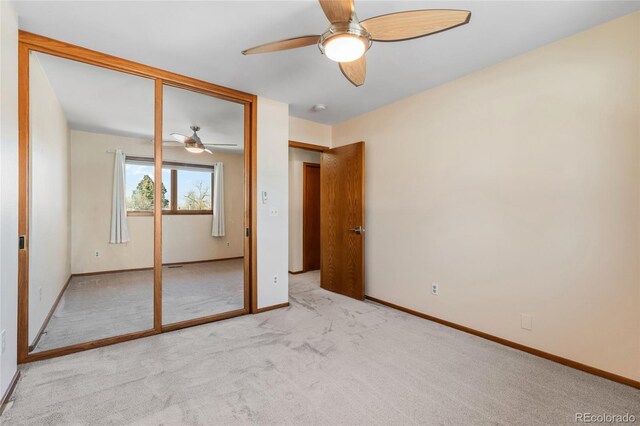 unfurnished bedroom with light colored carpet, ceiling fan, and a closet