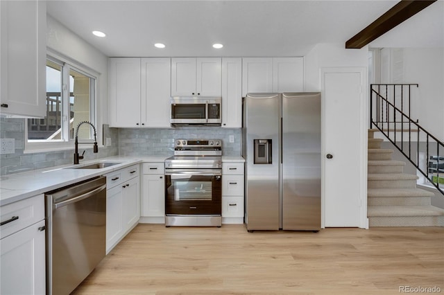 9605 Carr St, Broomfield, CO 80021 - kitchen with stainless steel appliances, a sink, white cabinets, tasteful backsplash, and recessed lighting