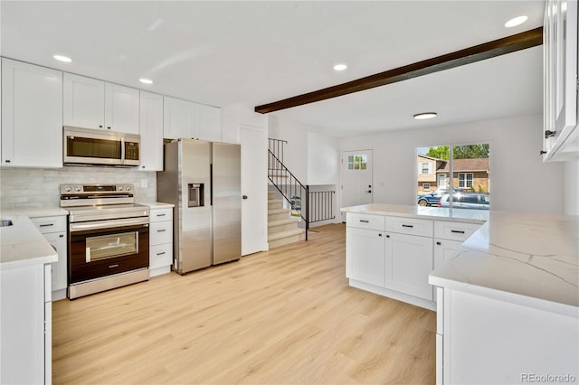 9605 Carr St, Broomfield, CO 80021 - kitchen with stainless steel appliances, light wood-type flooring, white cabinets, light stone counters, and beamed ceiling