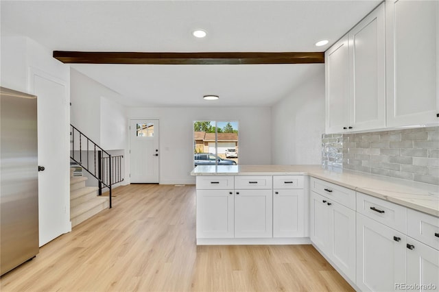 9605 Carr St, Broomfield, CO 80021 - kitchen featuring beam ceiling, stainless steel refrigerator, a peninsula, light wood-style flooring, and white cabinetry