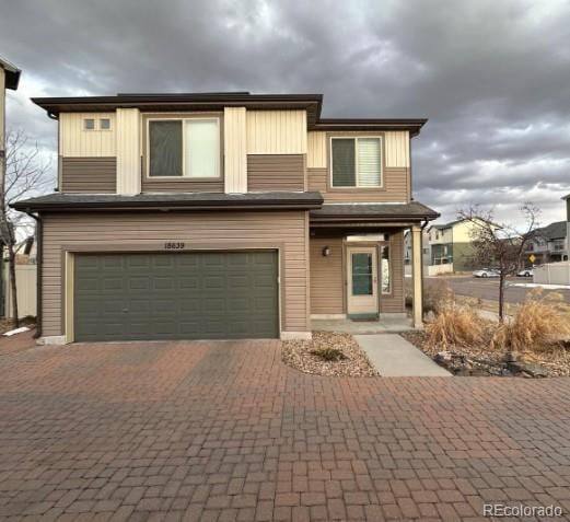 view of front of property with a garage and decorative driveway