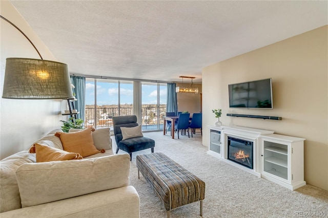 living room with a wall of windows, a notable chandelier, carpet, and a textured ceiling