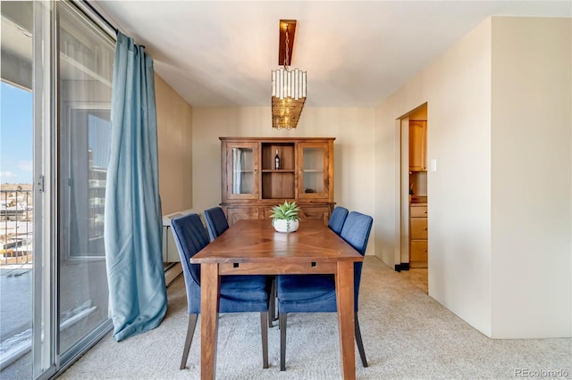 dining room with baseboard heating and light colored carpet