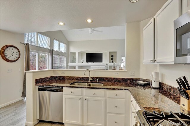 21541 Unbridled Ave, Parker, CO 80138 - kitchen with appliances with stainless steel finishes, a sink, dark stone counters, white cabinetry, and recessed lighting
