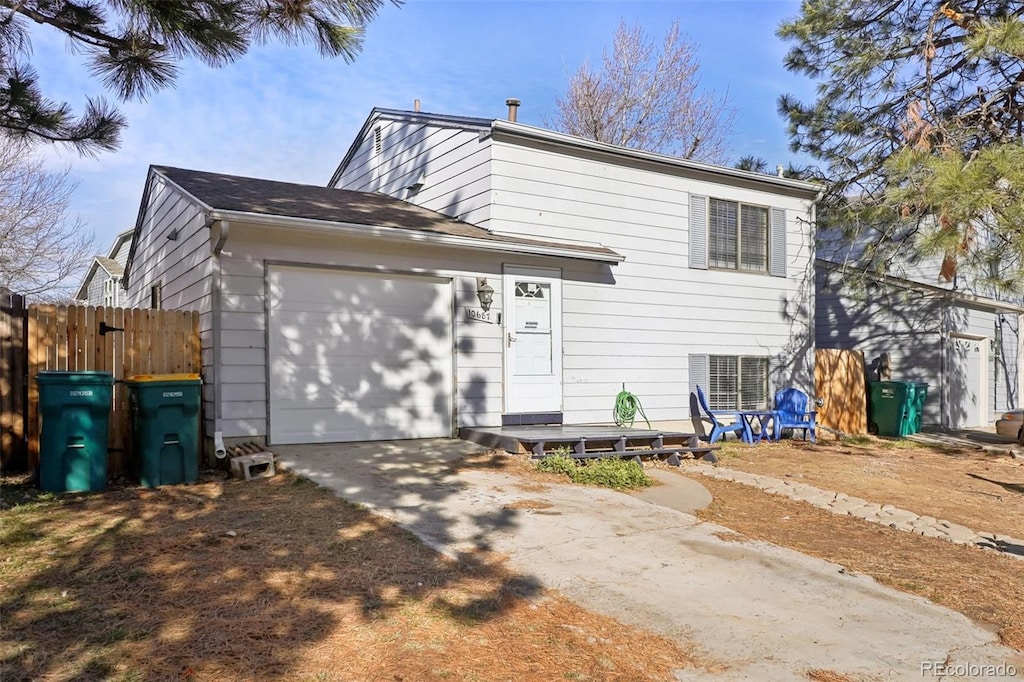 split level home with central AC unit and a garage