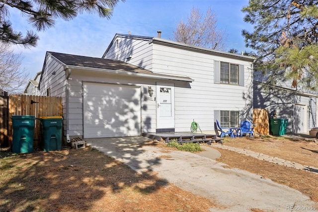 split level home with central AC unit and a garage