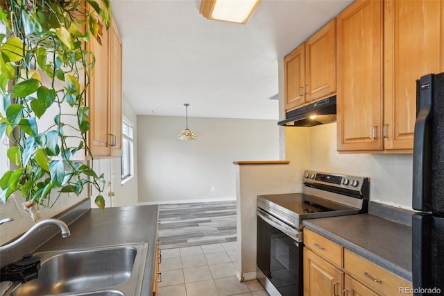 kitchen with electric range, sink, black fridge, pendant lighting, and light tile patterned flooring