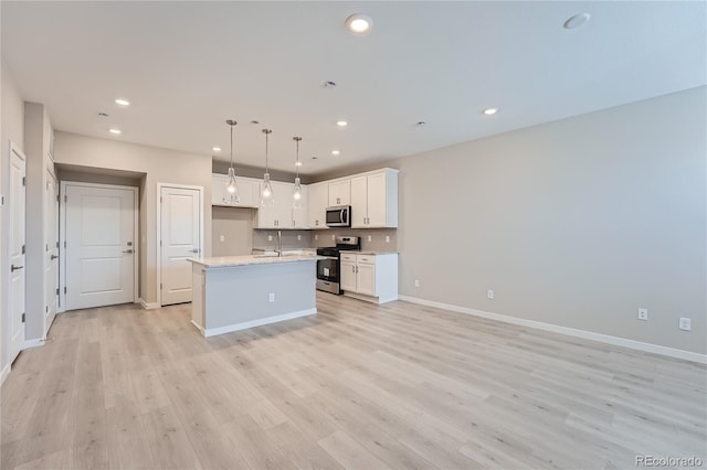 kitchen featuring pendant lighting, a kitchen island with sink, white cabinets, light hardwood / wood-style flooring, and stainless steel appliances