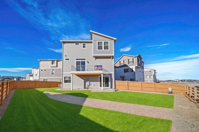 rear view of property with a lawn, a patio area, and a balcony