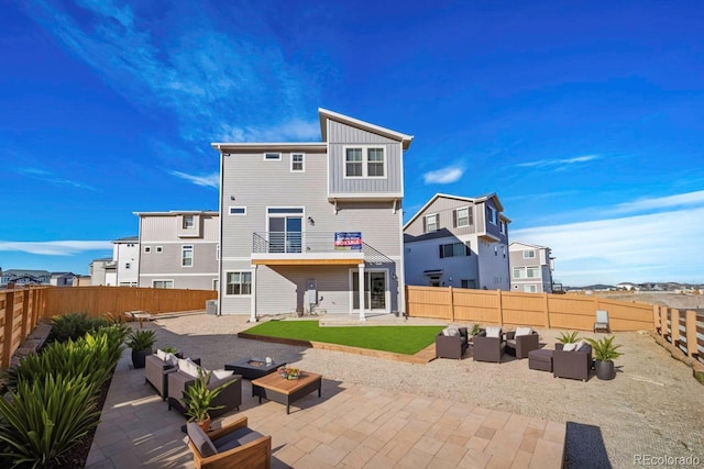 rear view of house with a yard, a patio area, an outdoor living space, and a balcony