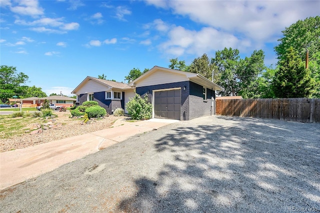 1596 S Stuart St, Denver, CO 80219 - single story home with a garage, driveway, and brick siding