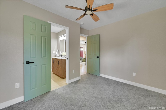 1596 S Stuart St, Denver, CO 80219 - unfurnished bedroom featuring light colored carpet, ensuite bath, and a ceiling fan