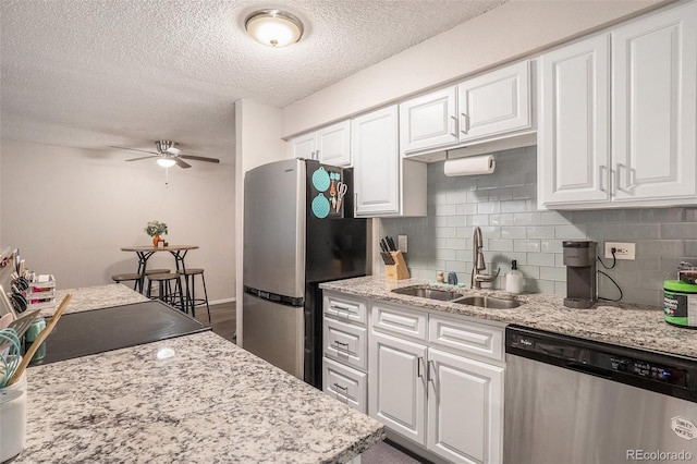 kitchen featuring a sink, white cabinets, backsplash, and stainless steel appliances