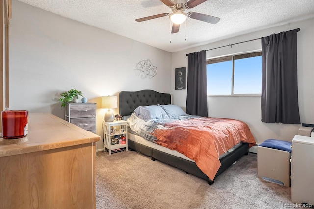 bedroom with a textured ceiling, ceiling fan, and light carpet