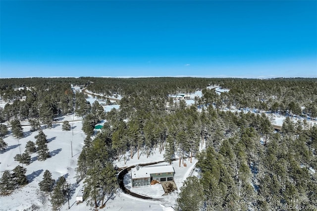 snowy aerial view featuring a forest view