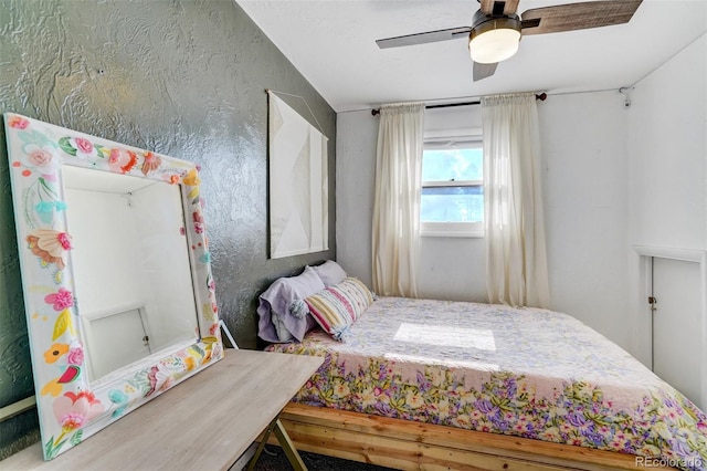 bedroom featuring a textured wall and a ceiling fan