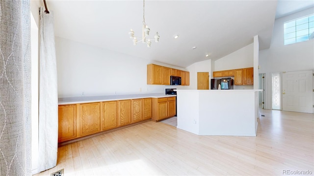 2314 Flagstaff Dr, Longmont, CO 80504 - kitchen featuring black microwave, refrigerator, a chandelier, light wood-style flooring, and high vaulted ceiling