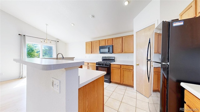 2314 Flagstaff Dr, Longmont, CO 80504 - kitchen featuring black appliances, vaulted ceiling, light countertops, a center island with sink, and light tile patterned flooring
