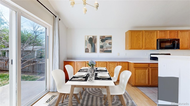 2314 Flagstaff Dr, Longmont, CO 80504 - dining area featuring light wood-style flooring, a chandelier, and lofted ceiling