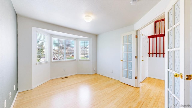2314 Flagstaff Dr, Longmont, CO 80504 - unfurnished room featuring french doors, wood finished floors, a smoke detector, and baseboards