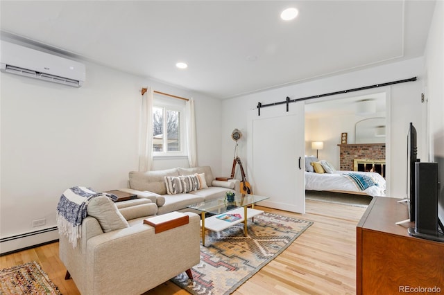 5115 Bryant St, Denver, CO 80221 - living room featuring a wall mounted AC, light wood finished floors, a baseboard radiator, a barn door, and recessed lighting