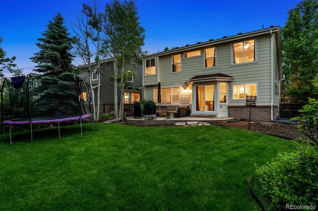 1441 Cherry Pl, Erie, CO 80516 - back of property at dusk with a trampoline and a patio