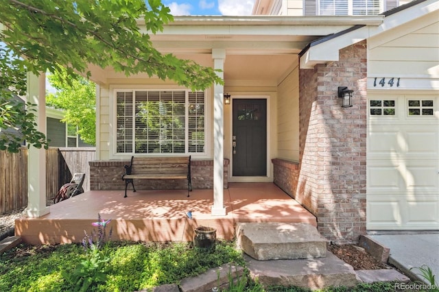 1441 Cherry Pl, Erie, CO 80516 - property entrance with covered porch, a garage, and brick siding