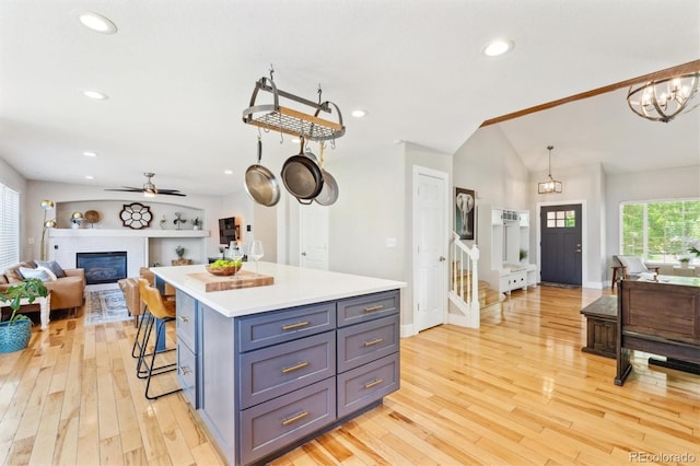 1441 Cherry Pl, Erie, CO 80516 - kitchen featuring open floor plan, light wood-type flooring, lofted ceiling, light countertops, and a breakfast bar area