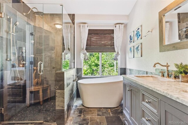 1441 Cherry Pl, Erie, CO 80516 - full bathroom with vanity, a freestanding tub, a stall shower, and stone finish flooring