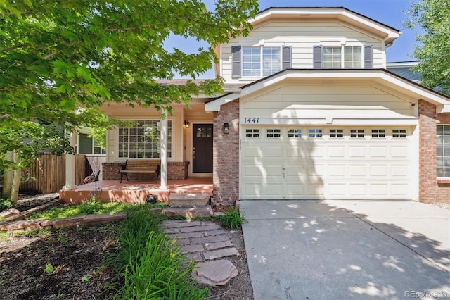 1441 Cherry Pl, Erie, CO 80516 - traditional-style house featuring brick siding, driveway, an attached garage, and a porch