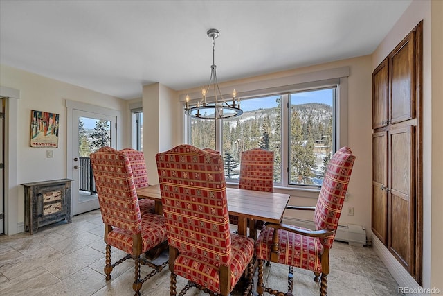 dining room with a mountain view, a baseboard heating unit, and a notable chandelier