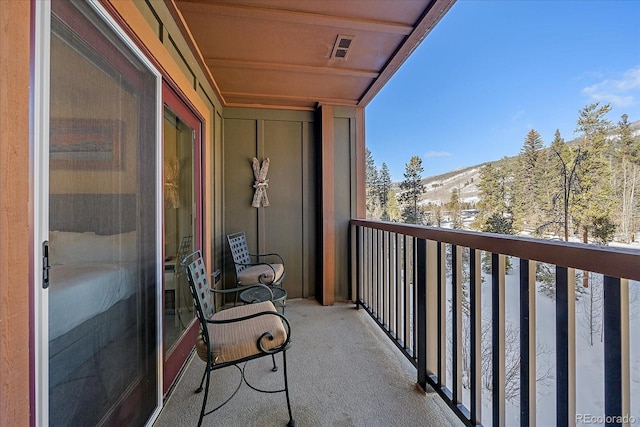 snow covered back of property with a mountain view