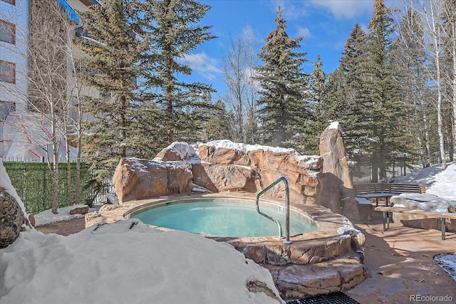 snow covered pool featuring a hot tub