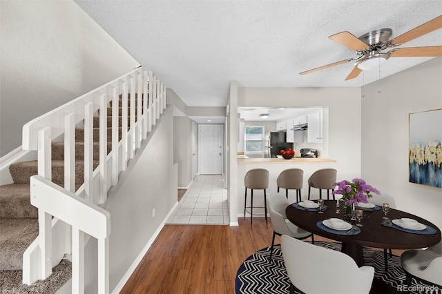 dining area featuring ceiling fan, a textured ceiling, and light hardwood / wood-style floors