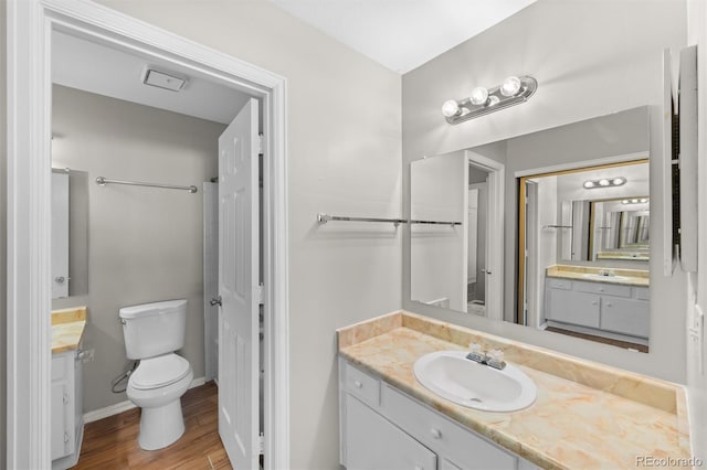 bathroom with vanity, toilet, and hardwood / wood-style flooring