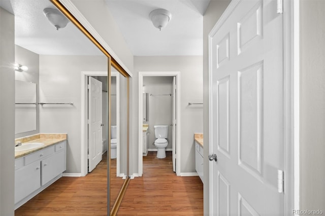 bathroom featuring wood-type flooring, vanity, and toilet