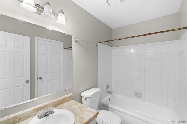 full bathroom with tiled shower / bath, vanity, and toilet