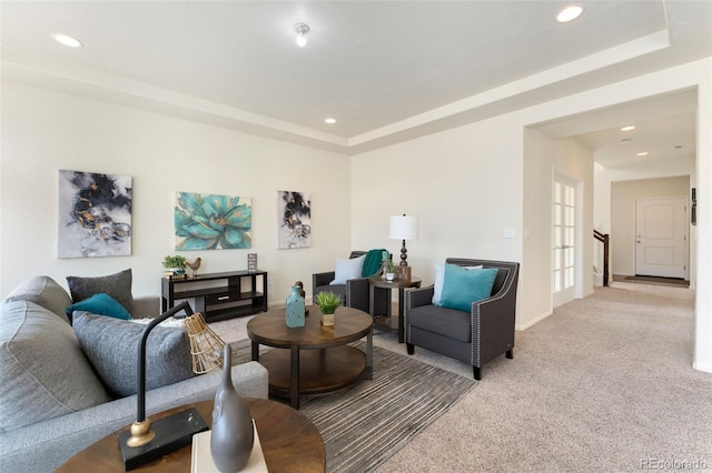 living room with light carpet, recessed lighting, and a raised ceiling