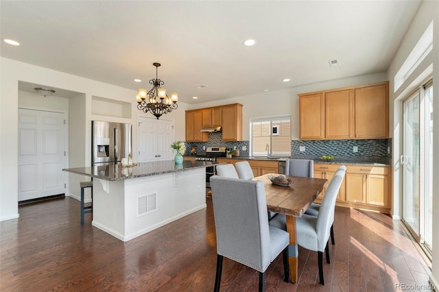dining area with visible vents, recessed lighting, dark wood-style flooring, baseboards, and a notable chandelier