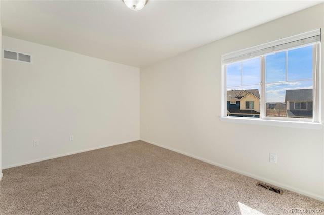 empty room with visible vents, baseboards, and carpet