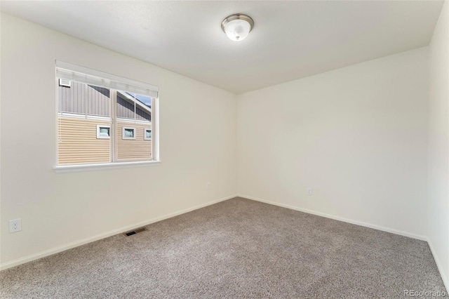 carpeted empty room featuring baseboards and visible vents