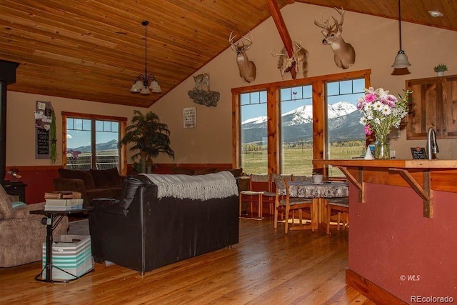 living room with an inviting chandelier, hardwood / wood-style floors, wood ceiling, high vaulted ceiling, and a mountain view