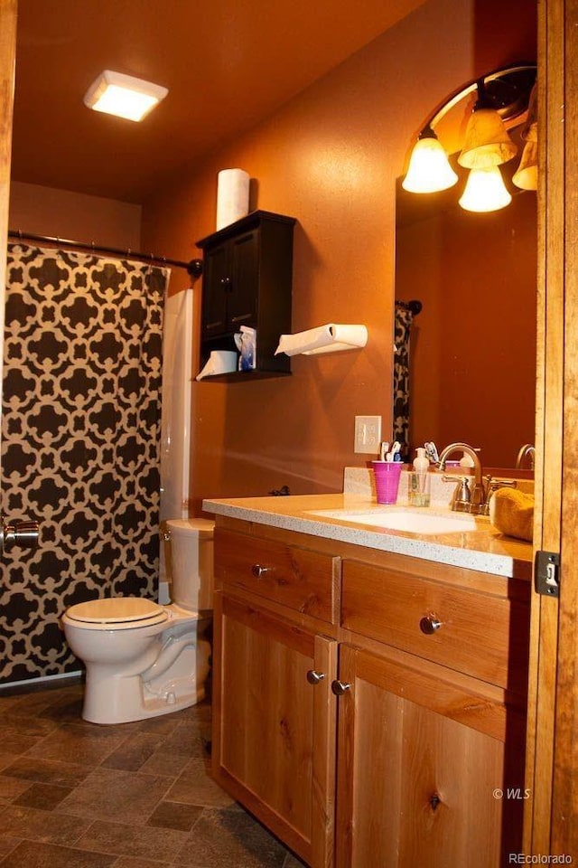 bathroom featuring tile flooring, vanity, and toilet